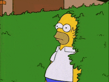 Homer Simpson retreating into the bushes.